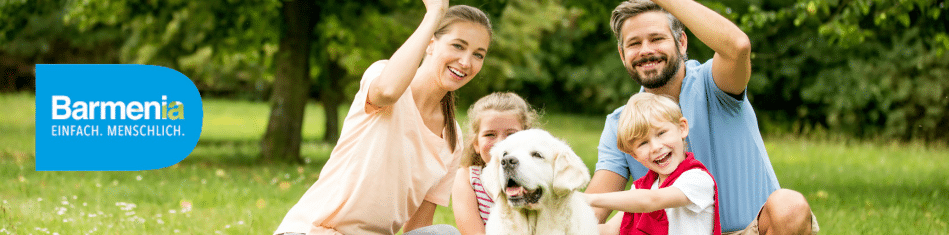 Glückliche Familie mit Hund auf einer Wiese mit Barmenia Logo